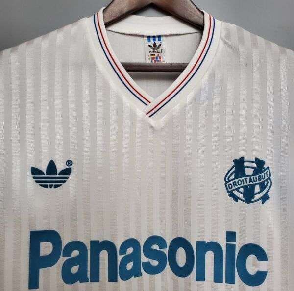 Zoom sur le col, logos et sponsor du Maillot OM 91.
