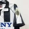 Présente la manche et col du maillot vintage Juventus Domicile 1997/1998