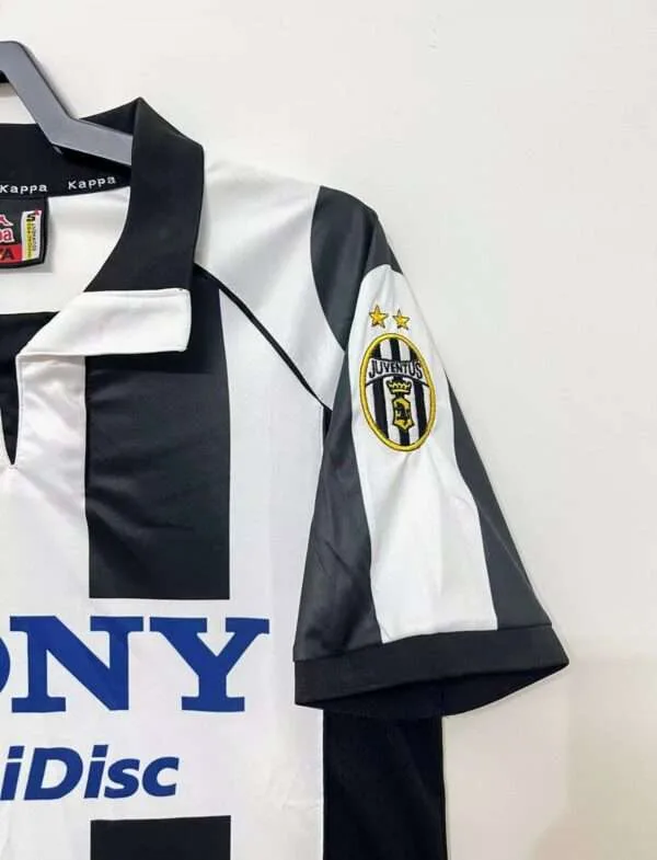 Présente la manche et col du maillot vintage Juventus Domicile 1997/1998