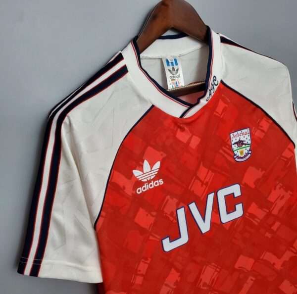 Présente la manche et col du maillot vintage Arsenal Domicile 1990/1992