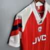 Présente la manche et col du maillot vintage Arsenal Domicile 1992/1994