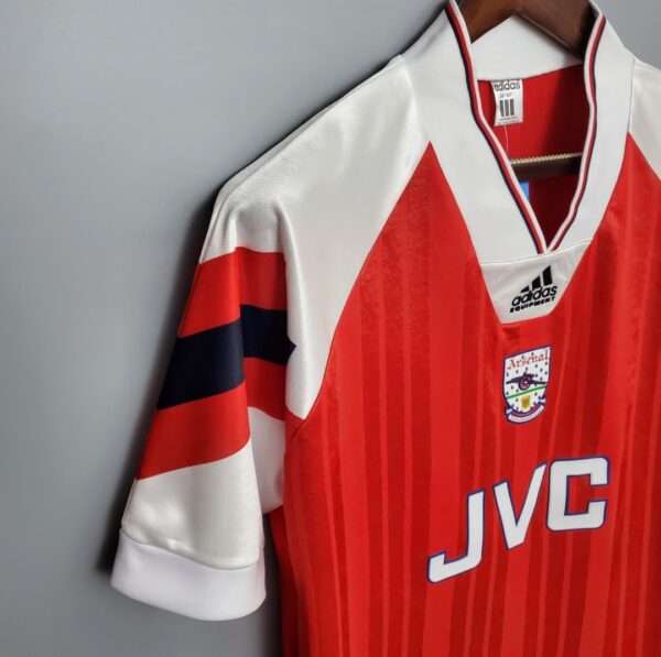 Présente la manche et col du maillot vintage Arsenal Domicile 1992/1994