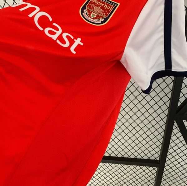 Présente la manche et coutures du maillot vintage Arsenal Domicile 2000/2002
