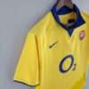 Présente la manche et col du maillot vintage Arsenal Extérieur 2003/2005