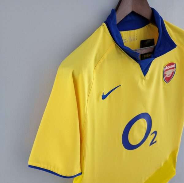 Présente la manche et col du maillot vintage Arsenal Extérieur 2003/2005