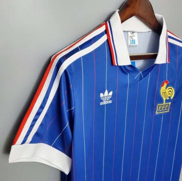 Présente la manche, col et logos du maillot vintage France Domicile Coupe du Monde 1982