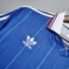 Présente le col et logo du maillot vintage France Domicile Coupe du Monde 1982