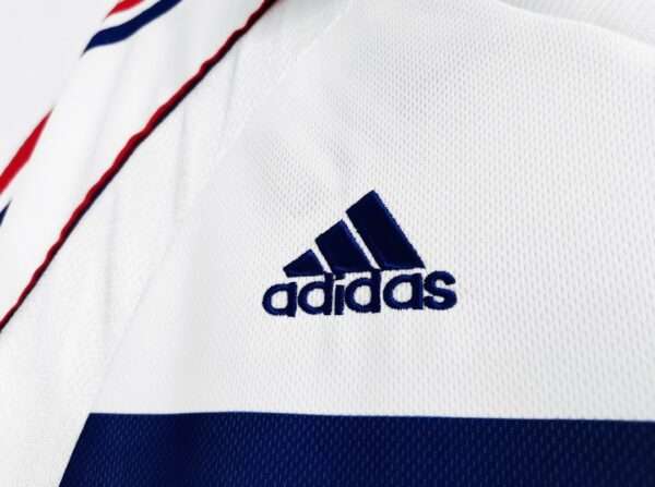 Zoom sur le logo et coutures du maillot vintage France Extérieur Coupe du Monde 1998