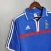 Présente la manche, col et logos du maillot vintage France Domicile Euro 2000