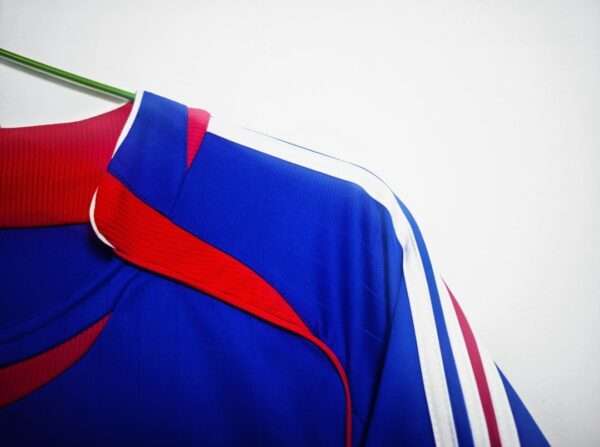 Présente la manche et coutures du maillot vintage France Domicile Coupe du Monde 2006