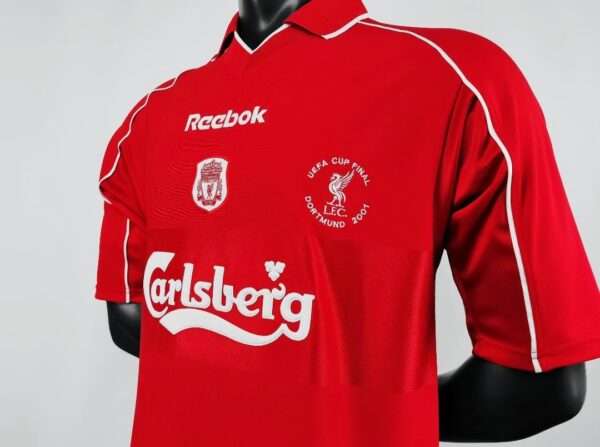 Présente la manche, col et logos du maillot vintage Liverpool Finale Coupe UEFA 2001