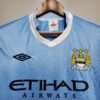 Zoom sur les logos et col du maillot vintage Manchester City Domicile 2011/2012