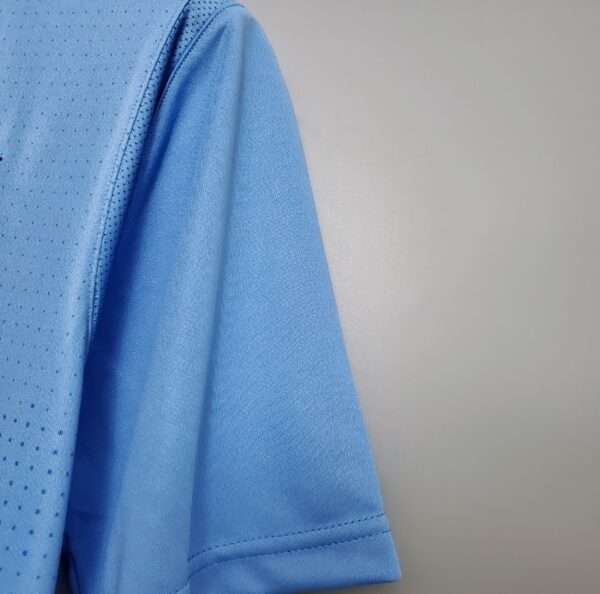 Présente la manche et coutures du maillot vintage Manchester City Domicile 2011/2012