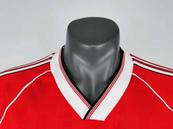 Présente le col du maillot vintage Manchester United Domicile 1988/1990