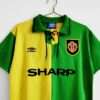 Présente les manches, col et logos du maillot vintage Manchester United "Troisième" 1992/1994