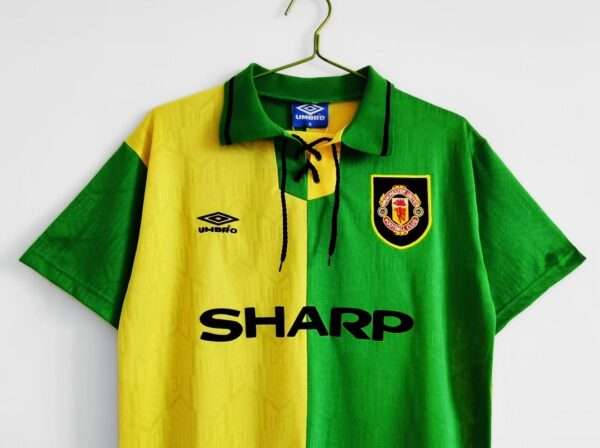Présente les manches, col et logos du maillot vintage Manchester United "Troisième" 1992/1994