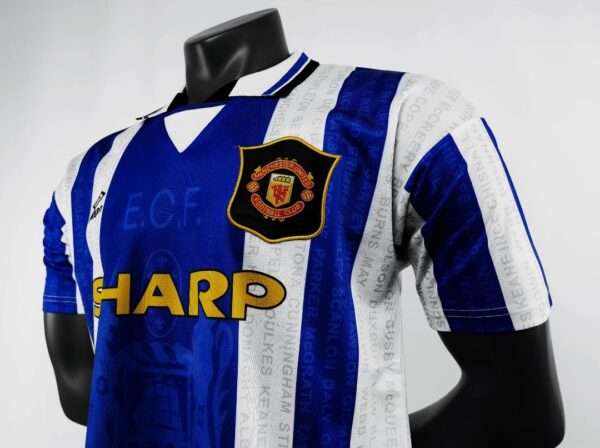 Zoom sur les manches, col et logos du maillot vintage Manchester United "Troisième" 1994/1996