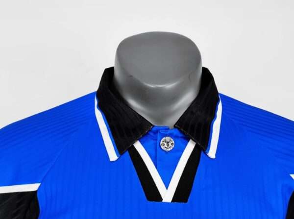 Présente le col du maillot vintage Manchester United Domicile 1996/1998