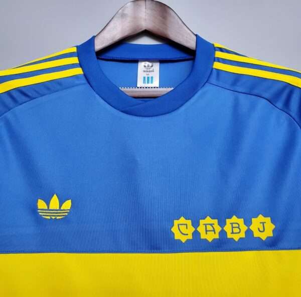 Présente le col et logos du maillot vintage Boca Juniors Domicile 1981/1982