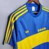 Présente la manche, col et logos du maillot vintage Boca Juniors Domicile 1981/1982