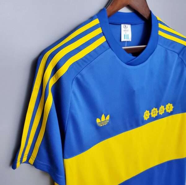 Présente la manche, col et logos du maillot vintage Boca Juniors Domicile 1981/1982
