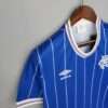 Présente la manche, col et logos du maillot vintage Glasgow Rangers Domicile 1982/1983