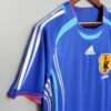 Présente la manche, col et logos du maillot vintage Japon Domicile Coupe du Monde 2006