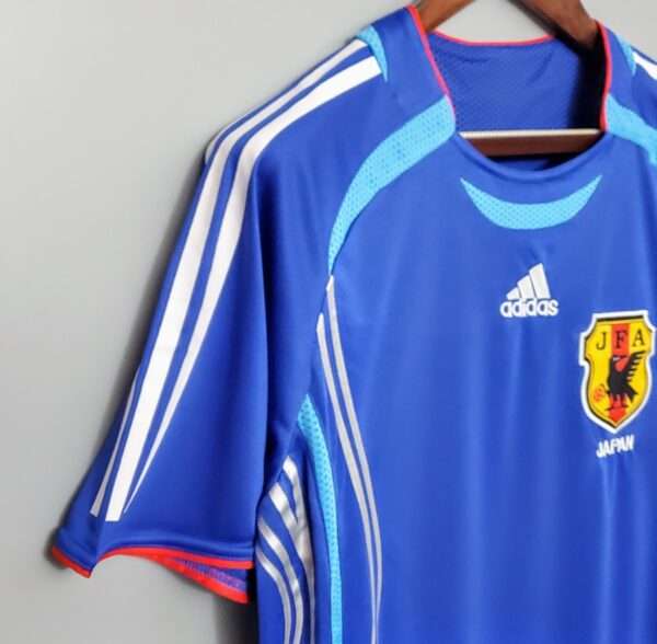 Présente la manche, col et logos du maillot vintage Japon Domicile Coupe du Monde 2006