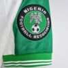 Présente la manche et logo du maillot vintage Nigeria Extérieur Jeux Olympiques 1996