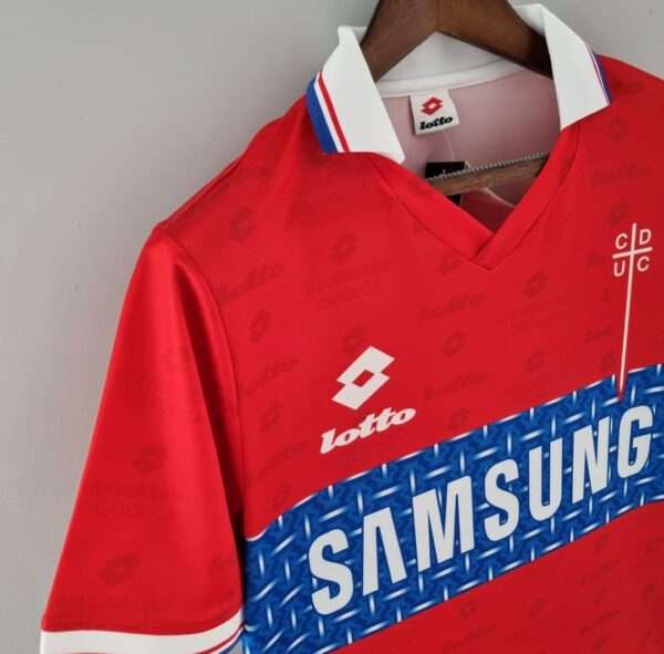 Présente la manche, col et logos du maillot vintage Universidad Católica Extérieur 1996/1997