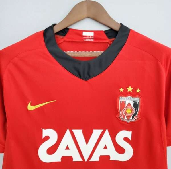 Présente le col et logos du maillot vintage Urawa Red Diamonds Domicile 2008/2009