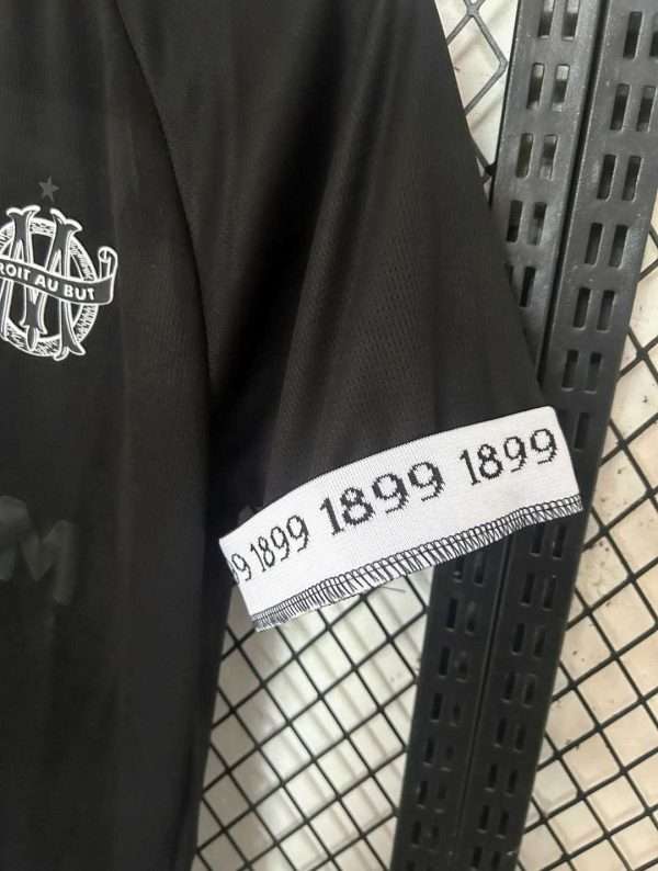 Présente la manche et coutures du maillot vintage Olympique de Marseille Gardien "125 Ans"