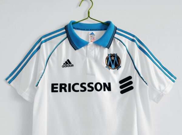 Présente les manches et col du maillot vintage Olympique de Marseille Domicile "Centenaire" 1998/1999