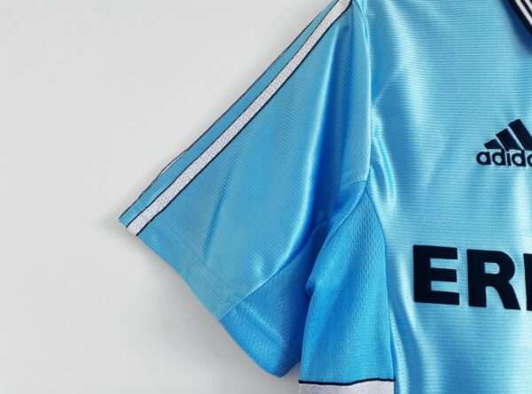 Présente la manche et coutures du maillot vintage Olympique de Marseille Extérieur "Centenaire" 1998/1999