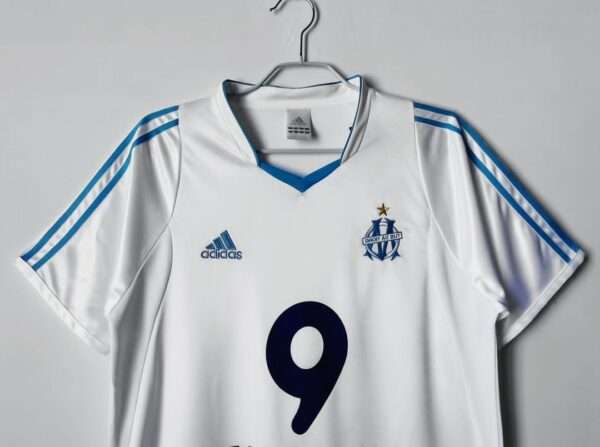Présente les manches, col et logos du maillot vintage Olympique de Marseille Domicile 2003/2004