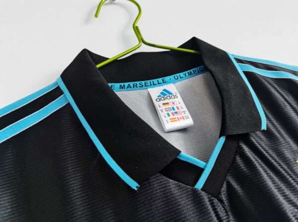 Présente le col avant du maillot vintage Olympique de Marseille "Troisième" 1999/2000