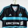 Présente les manches, col et logos du maillot vintage Olympique de Marseille "Troisième" 1999/2000